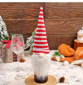 Festive red and white striped knitted gnome wine bottle cover for Christmas table decor