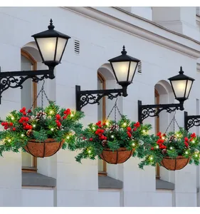 Detailed view of artificial Christmas hanging baskets with warm LED lights and red berries.