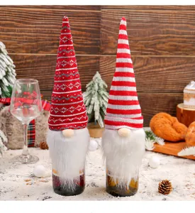 Close-up of red and white knitted gnome wine bottle covers for Christmas table decor