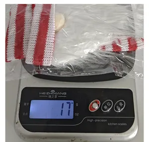 Measurement showing the 17g weight of a striped knitted Christmas gnome wine bottle cover