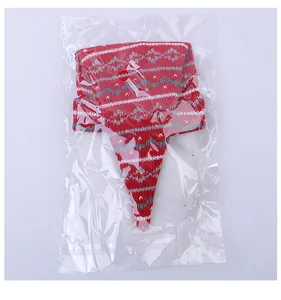 Close-up of a red and white knitted Christmas bottle topper inside a transparent plastic bag