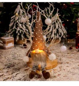 Nahaufnahme eines leuchtenden Weihnachtswichtels mit brauner Strickmütze und Beinen
