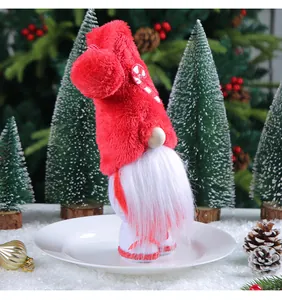 Detail of a plush Christmas gnome with red furry hat and candy cane decoration.