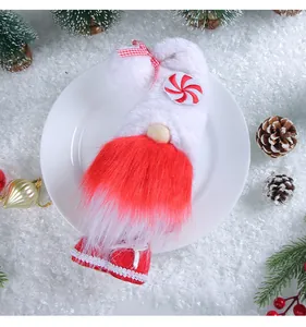 Detailed shot of plush Christmas gnome decoration on white plate with festive props