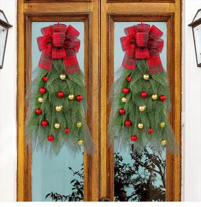 Decorative Christmas teardrop wreath with red plaid bow and festive ornaments on wooden door