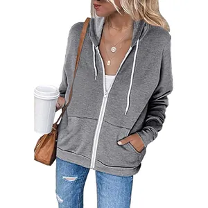 Detail shot of a casual women's grey zip-up hoodie with front pockets and white drawstrings.