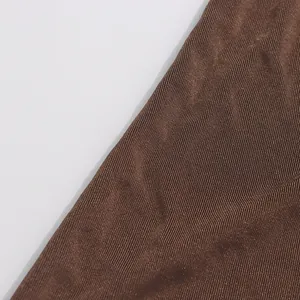 Gros plan sur la texture du tissu plissé à côtes verticales marron pour robe d'été sans manches