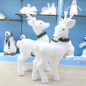 Détail de grandes décorations de rennes de Noël floqués blancs avec colliers festifs