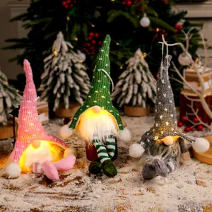 Drei leuchtende Weihnachtswichtel mit Strickmützen und baumelnden Beinen in Feststimmung.