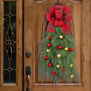 Festive Christmas swag wreath with red plaid bow and ornaments for front door holiday decor