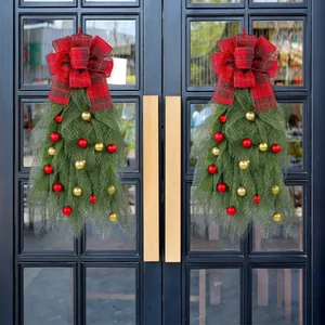 Festive Christmas tree wreath with red plaid bow and ornaments on double doors.