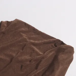 Gros plan sur le tissu texturé marron et les détails plissés de la robe longue d'été.