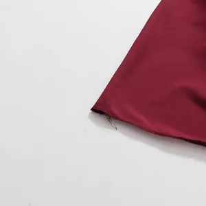 Detaillierte Makroansicht des weinroten Kleidsaums und der hochwertigen Stoffstruktur