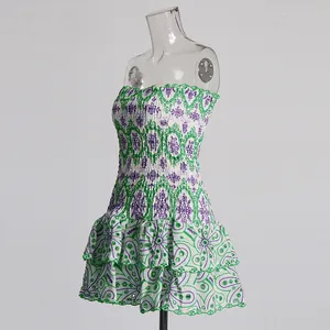 Détail d'une robe bustier blanche avec des broderies florales violettes et vertes et volants.