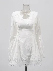 Vestido corto blanco de manga larga con cuello en V y bordado floral sofisticado.