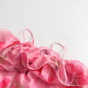 Detailansicht des gerafften Ausschnitts und der dünnen Träger eines rosa Blumenkleides.