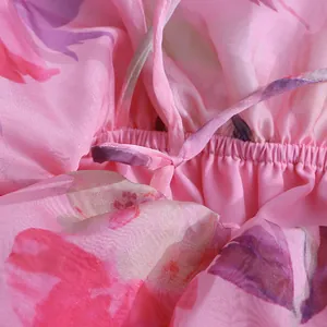 Détail de la taille élastique et du cordon sur une robe de plage en mousseline rose.