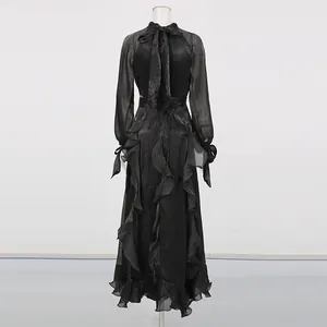 Back view of vintage black high-neck dress with bow tie and ruffled skirt detail