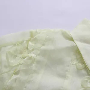Vue macro détaillée du tissu en mousseline jaune avec des fleurs à volants