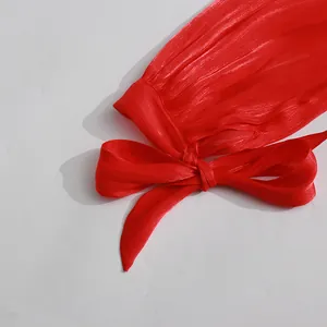 Macro view of a pleated red dress sleeve featuring an elegant bow tie cuff detail