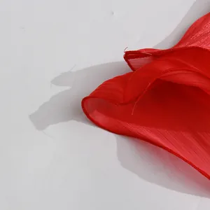 Close-up of vibrant red textured fabric with fine stitching detail