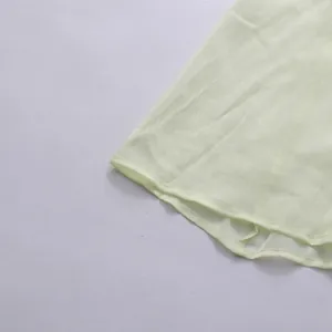 Vue détaillée de l'ourlet en mousseline texturée sur une robe jaune de style français