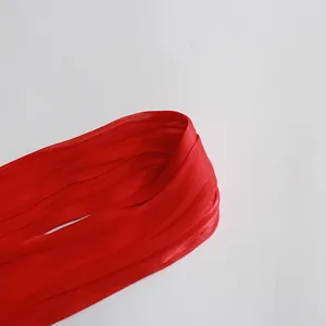 Close-up detail of the elegant red pleated necktie on a vintage summer dress fabric