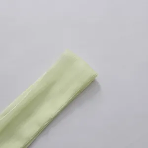 Gros plan sur le tissu texturé vert clair de cette robe chemise de style français