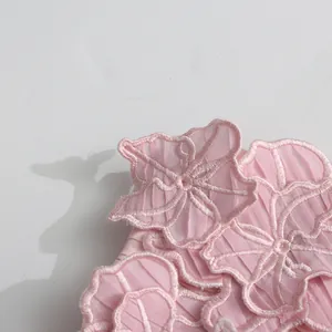 Detailed macro view of pink embroidered floral pattern on elegant pleated fabric
