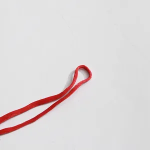 Close-up macro detail of the red satin tie-up strap on a vintage palace style dress.