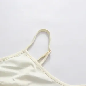 Gros plan sur la bandoulière réglable d'une robe en satin crème de style français