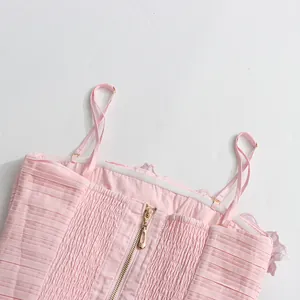 Detailed view of the pink camisole dress showing adjustable straps and back zipper