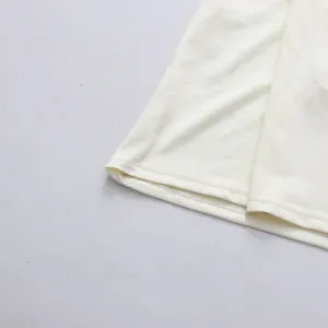 Gros plan sur les doubles coutures soignées de l'ourlet d'une robe en mousseline.
