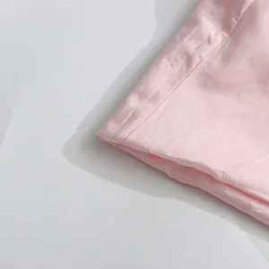 Close-up detail of the neat stitching and soft pink fabric texture on a sweet style dress