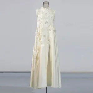 Détail d'une élégante robe longue blanche sans manches à col montant avec fleurs en relief