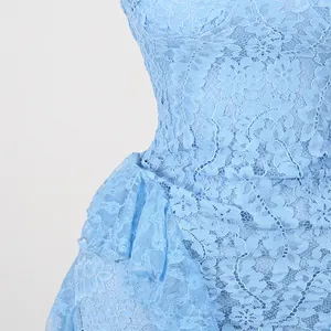 Gros plan détaillé montrant le motif floral complexe en dentelle bleu clair de la robe