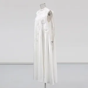 Détail de profil d'une élégante robe maxi blanche sans manches à appliqués floraux 3D.