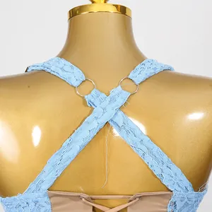 Détail des bretelles croisées en dentelle florale avec anneaux métalliques sur robe bleue
