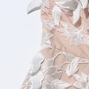 Close-up of intricate white floral embroidery on mesh fabric of a vintage tube top dress