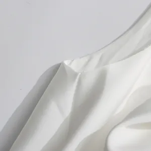 Détail en gros plan du tissu blanc lisse et de la couture d'emmanchure d'une robe élégante.