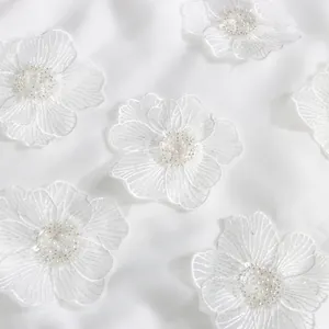 Détail de patchs de fleurs en dentelle blanche brodée avec perles et paillettes