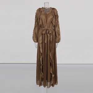 Elegant brown shimmering pleated maxi dress with ruffled V-neck and belted waist on mannequin