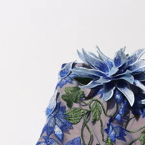 Detail shot showing intricate 3D blue flower embroidery on elegant purple mesh dress