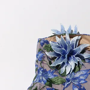 Close-up of elegant blue floral embroidery and 3D applique on vintage mesh dress.