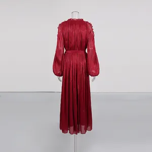 Back view of an elegant pleated wine red maxi dress with silky finish on a mannequin.
