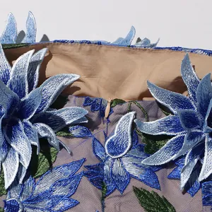 Close-up detail showing exquisite blue floral embroidery and hidden zipper on mesh dress