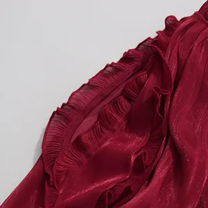 Detailed close-up of shiny wine red mercerized fabric with elegant ruffled edges