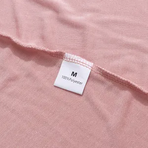 Detailed close-up of soft pink stretch fabric and wash tag showing 100% Polyester content