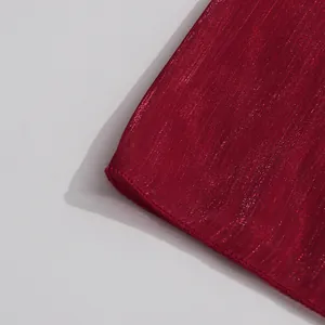 Close-up detail of luxury red shiny mercerized fabric hem on a minimalist French dress