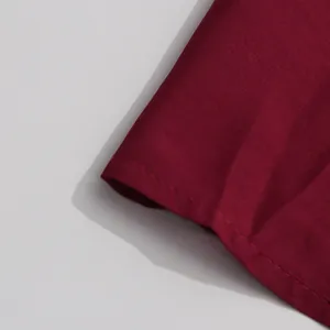 Detailed view of the wine red mercerized fabric hem with precise stitching workmanship